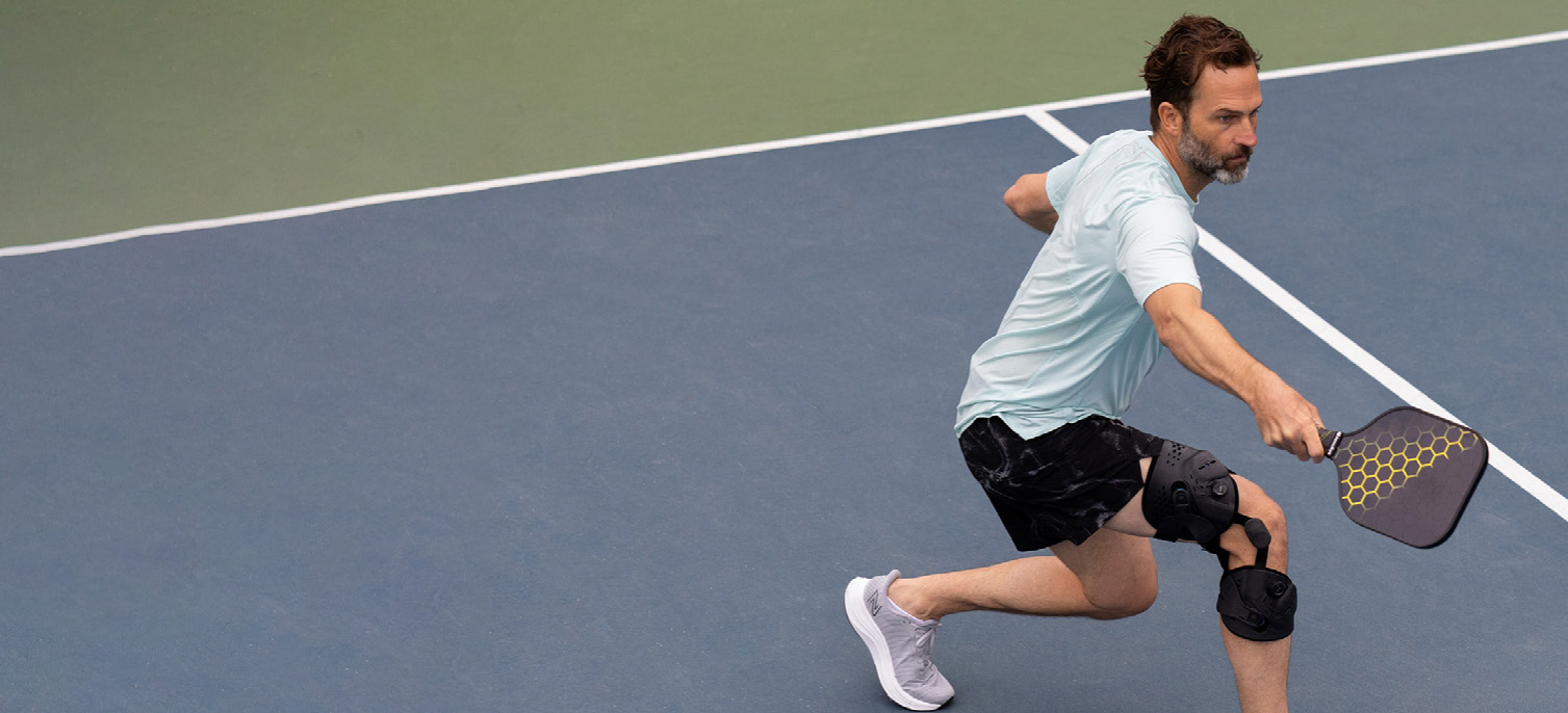 Active tennis player wearing professional orthopaedic knee braces while playing on court - Dupuis Custom Bracing helps you get back in the game